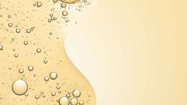 Goldfarbener Flüssigkeitshintergrund mit zahlreichen Blasen, die eine glatte, fließende Struktur bilden.