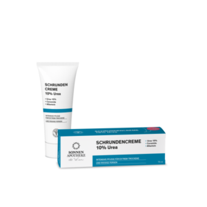 Schrundencreme in einer Tube und einer Verpackung, beide mit 10% Urea und Pflegehinweisen für trockene Haut.